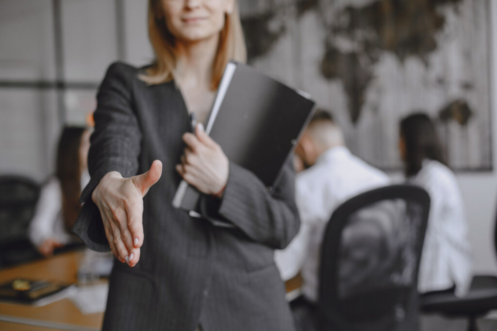 woman in a suit holds a folder.